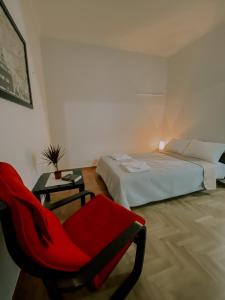 Un dormitorio con una silla roja y una cama en Jo Apartment, en Atenas