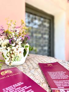 einen Tisch mit zwei Pässen und einer Vase Blumen in der Unterkunft Agriturismo I Prati di Venere in Sesta Godano