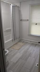 La salle de bains est pourvue d'une douche et de toilettes. dans l'établissement Beautiful and Cozy Home in Binghamton, à Binghamton