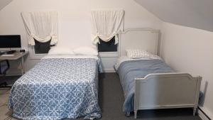 - une chambre avec 2 lits, un bureau et 2 fenêtres dans l'établissement Beautiful and Cozy Home in Binghamton, à Binghamton