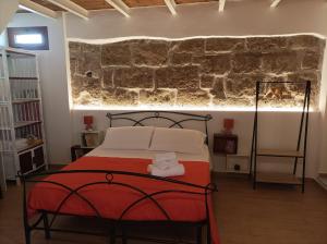 una camera con letto e parete in pietra di Ninfa Alghero ad Alghero