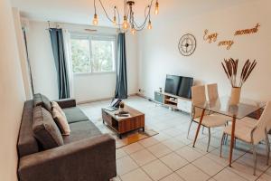 a living room with a couch and a table at Apparthotel - Paradis Médiéval in Poitiers