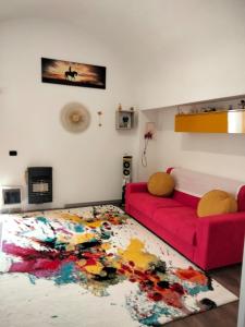 een woonkamer met een rode bank en een kleurrijk tapijt bij Che bella vita! in Monopoli