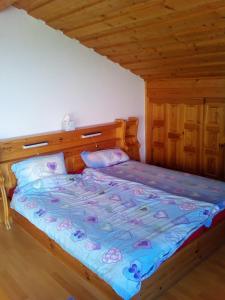 een bed met een houten hoofdeinde en kussens in een kamer bij Haus Alpenblick in Zenting