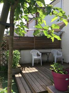 eine Terrasse mit zwei Stühlen und einem Tisch auf einem Deck in der Unterkunft Erdre Rivière Climatisé in La Chapelle-sur-Erdre + 16 Fotos