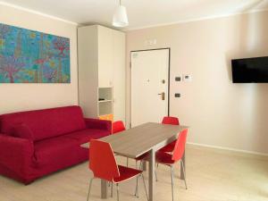 ein Wohnzimmer mit einem roten Sofa und einem Tisch in der Unterkunft La Casa del Mare in Sperlonga
