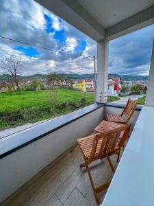 two chairs on a balcony with a view of a field at Happy Hill Rooms in Banja Luka