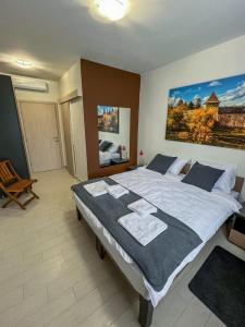 um quarto com uma cama grande e toalhas em Happy Hill Rooms em Banja Luka