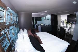 Demetria Hotel في غواذالاخارا: غرفة نوم بسرير ابيض كبير وبجدار