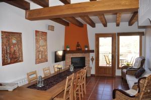 sala de estar con mesa y chimenea en El Rincón de la Trilla - El Linar en Horcajo de la Sierra