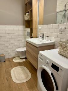 a bathroom with a washing machine and a sink at Żołnierska Olsztyn in Olsztyn