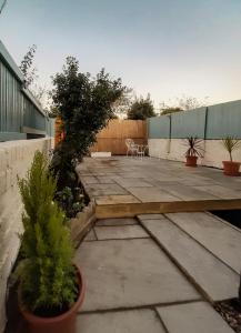 a patio with two potted plants and a table at Welcoming 4 Bed Holiday Home in Eastbourne in Eastbourne