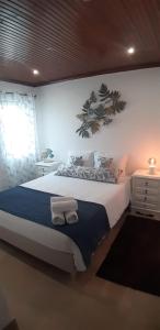 1 dormitorio con 1 cama grande y toallas. en A Casa da Foz Moradia com vista mar, en Sesimbra