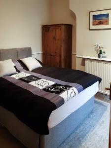 a bedroom with a bed with a black and white blanket at Welcoming 4 Bed Holiday Home in Eastbourne in Eastbourne