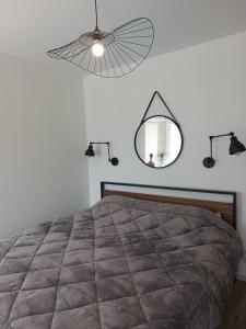 a bedroom with a bed with a mirror and lights at Studio2 Fontaine de L'amour in Sarlat-la-Canéda