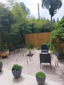 un patio con sillas, mesas y una valla en Studio2 Fontaine de L'amour en Sarlat-la-Canéda