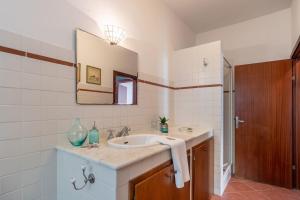a bathroom with a sink and a mirror at Belvedere apartment in Castiglione della Pescaia +18 photos
