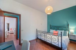 a bedroom with a bed and a blue wall at Belvedere apartment in Castiglione della Pescaia