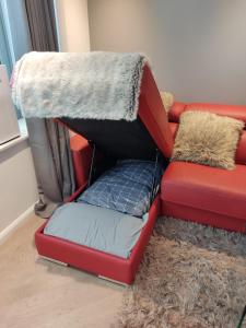 a red couch with a dog bed on top of it at Perfect Central London Base in London