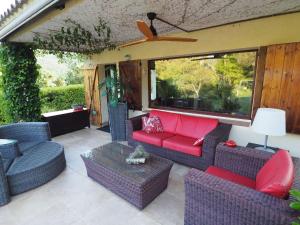 a patio with wicker furniture and a ceiling fan at Belvilla by OYO Vall Repos in Calonge