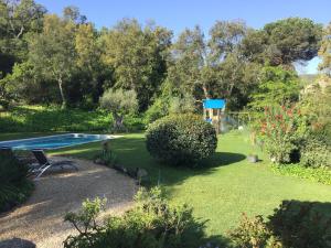 a garden with a swimming pool and trees at Belvilla by OYO Vall Repos in Calonge