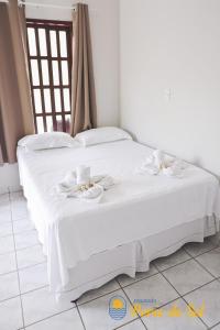 a white bed with white towels on top of it at Pousada Porto do Sol in Nova Viçosa +130 photos