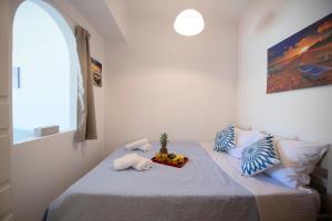 a bedroom with a bed with a bowl of fruit on it at Calliope Paradise Balcony in Panormos Kalymnos