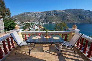 a table on a balcony with a view of the water at Calliope Paradise Balcony in Panormos Kalymnos