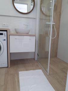a bathroom with a washing machine and a mirror at Przytulny Apartament nad morzem in Gdańsk