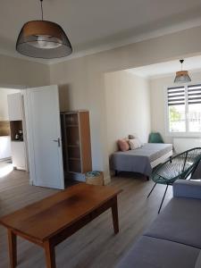 a living room with a bed and a table at EOLE - Maison Saint Jean de Monts - 2 pièces - 4 personnes in Saint-Jean-de-Monts