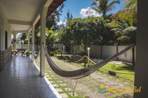 a hammock on the side of a house at Pousada Porto do Sol in Nova Viçosa