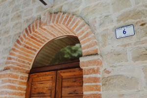 un arco de ladrillo sobre una puerta de madera en un edificio en Pratelli6 en Rosora