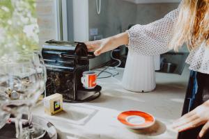 Eine Frau, die Kaffee in einen Toaster auf einer Küchentheke gießt. in der Unterkunft Pratelli6 in Rosora