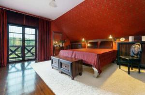 a bedroom with a bed and a red wall at WILLA NAD STAWEM MAZURY in Piecki