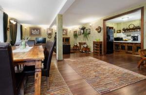 a living room with a wooden table and a kitchen at WILLA NAD STAWEM MAZURY in Piecki
