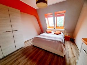a small bedroom with a bed and a window at Port Yellow in Giżycko