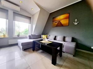 a living room with a couch and a table at Port Yellow in Giżycko