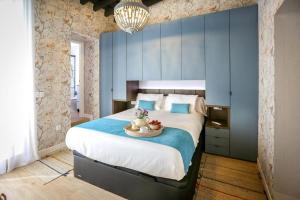 um quarto com uma cama grande e uma parede azul em El patio de Cristóbal Colón em Ayamonte
