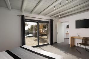 a bedroom with a bed and a sliding glass door at Ikies of Mykonos in Mýkonos City