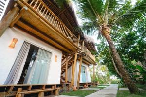 a building with a palm tree in front of it at Nomads Flats in Itacaré