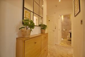 a bathroom with two potted plants on a wooden dresser at 'Malverne' at stayBOOM in Lancaster