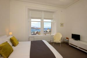 a bedroom with a large bed and a window at Greystones B&B in Oban