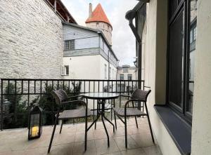 un patio con tavolo e sedie sul balcone. di Old Town - Viru Gate Apartment a Tallinn
