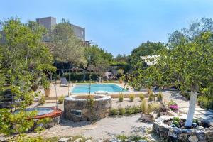 a swimming pool in a yard with trees and a building at The Red House in Dassia in Dassia