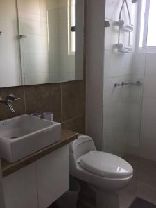 a bathroom with a white toilet and a sink at Beautiful Beach Apartment in Zazue in Santa Marta