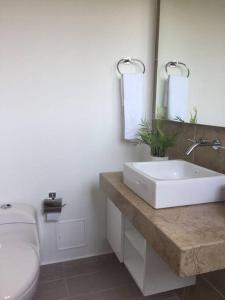 a bathroom with a white sink and a toilet at Beautiful Beach Apartment in Zazue in Santa Marta