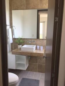 a bathroom with a sink and a toilet and a mirror at Beautiful Beach Apartment in Zazue in Santa Marta