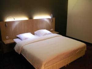 a hotel room with a bed and a lamp at Hotel Euro Capital Brussels in Brussels
