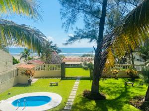 un patio trasero con piscina y vistas al océano en Quinta Duné Boutique... Un Paraíso Frente Al Mar!, en Chachalacas