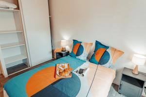 Un dormitorio con una cama con una bandeja de comida. en Apparthotel - Horizon Poitevin en Poitiers